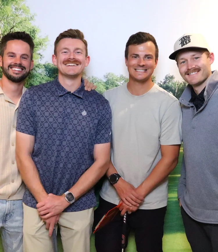 Four teammates posing together at the 2025 mini-golf fundraiser